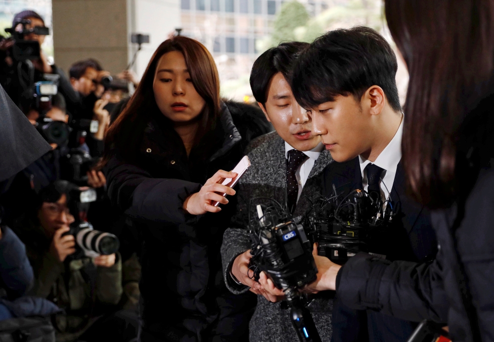 K-pop star Jung Joon-young (center) arrives for questioning at the Seoul Metropolitan Police Agency in Seoul, Thursday. — Reuters photos