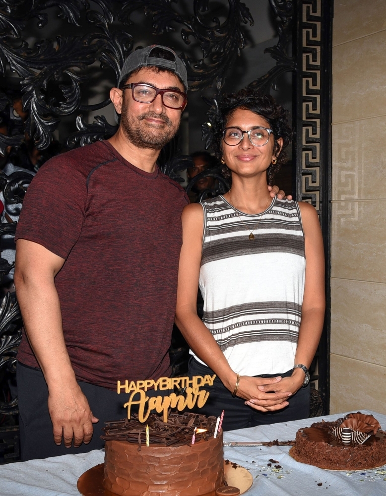Indian Bollywood actor and producer Aamir Khan (left) along with his wife, film director and screenwriter Kiran Rao Khan, pose for photographers on his 54th birthday at his residence in Mumbai, Thursday. — AFP 
