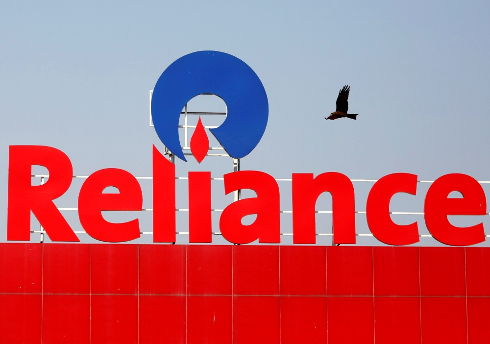 A bird flies past a Reliance Industries logo installed on its mart in Ahmedabad, India, in this file photo. — Reuters