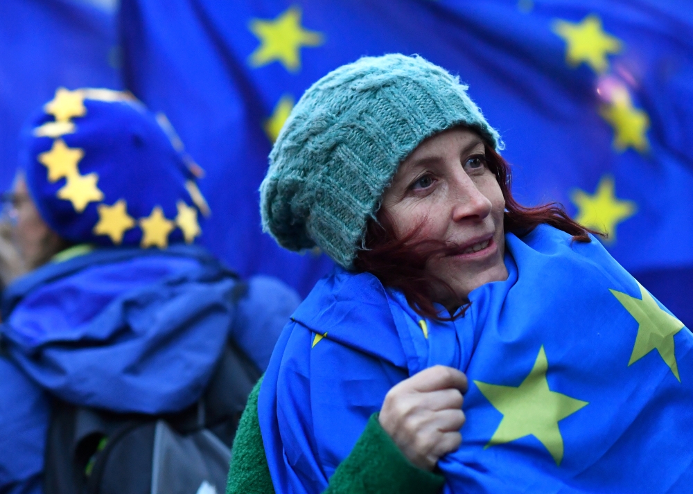 An anti-Brexit protester wears an EU flag outside the Houses of Parliament in London, Britain on Thursday. — Reuters