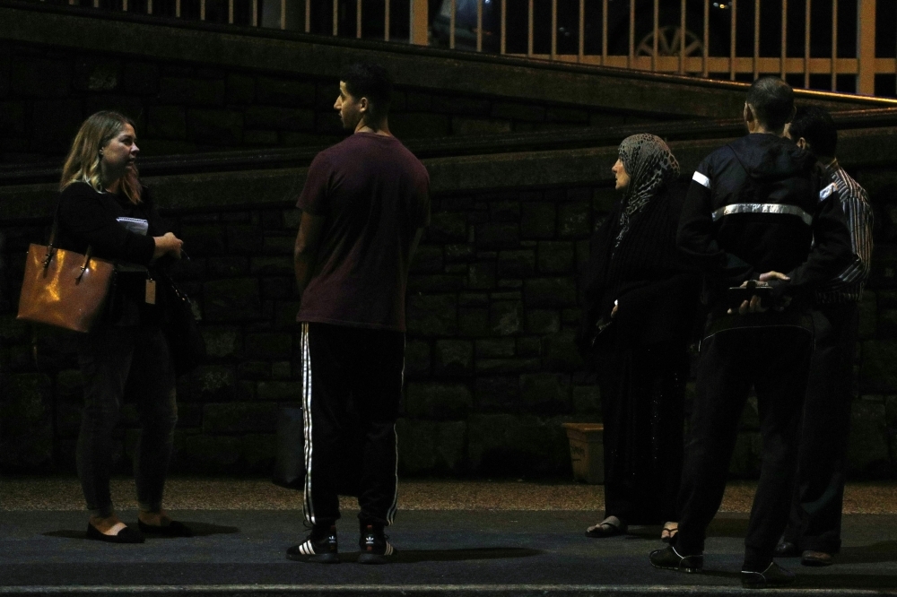 A Muslim family waits outside a hospital after a shooting incident in Christchurch on Friday. — AFP