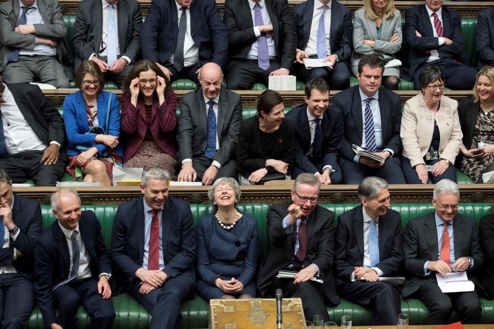 A handout photograph released by the UK Parliament on Thursday shows British Prime Minister Theresa May, center, reacting on the front bench in the House of Commons in London on Thursday. — AFP