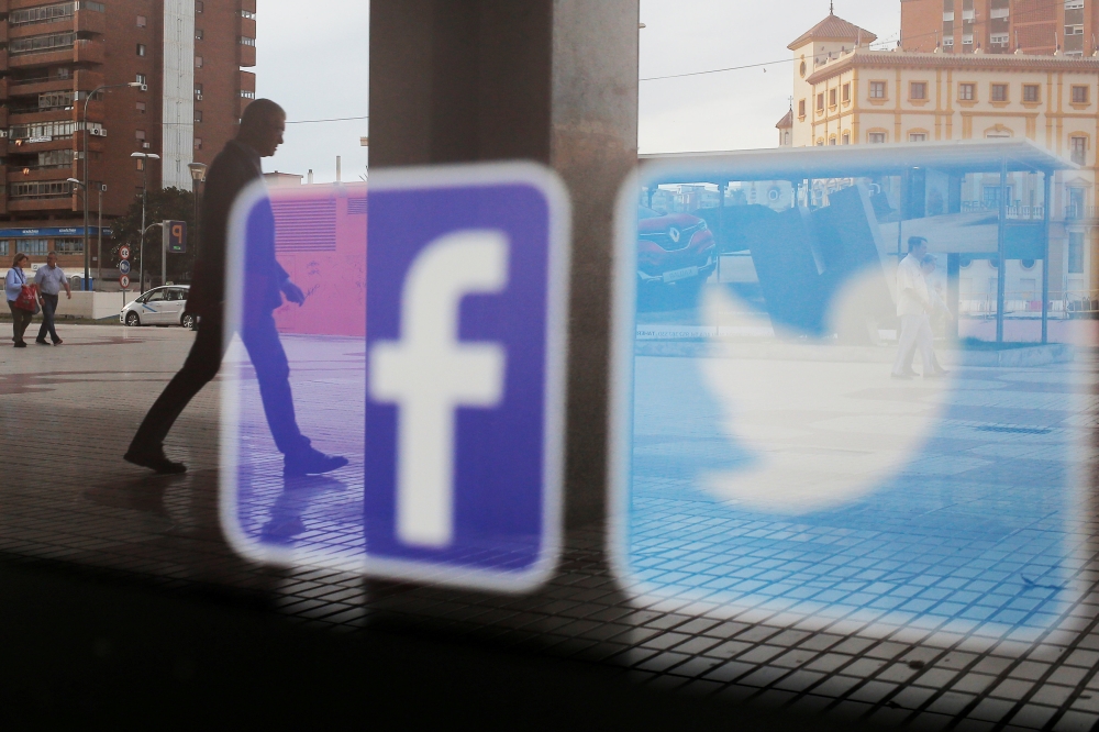 Facebook and Twitter logos are seen on a shop window in Malaga, Spain, in this June 4, 2018 file photo. — Reuters
