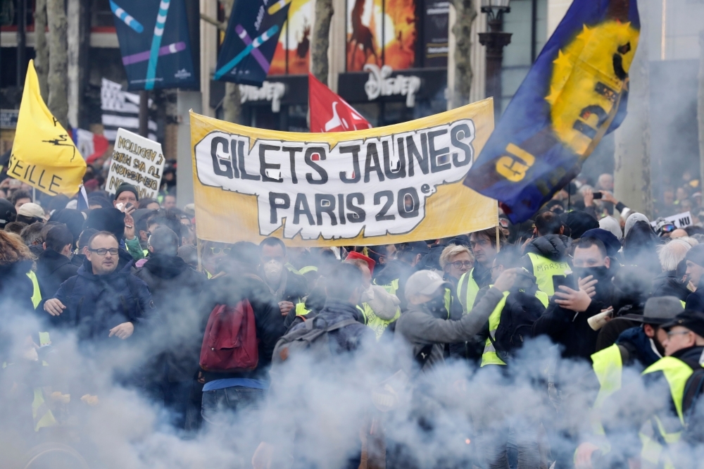 Yellow Vest protesters wave French regional flags on the Champs-Elysees in Paris during the 18th consecutive Saturday of demonstrations called by the 'Yellow Vest' (gilets jaunes) movement. — AFP