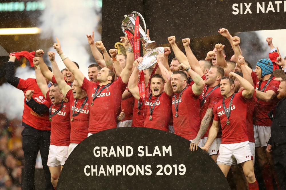 Wales players celebrate completing the Grand Slam and winning the Triple Crown and Six Nations Rugby Championship with the trophies at Principality Stadium, Cardiff, Saturday. — Reuters