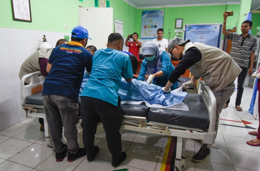 Indonesian medics move the body of a Malaysian national killed in a landslide caused by a 5.5-magnitude earthquake at Tiu Kelep waterfall, in Bayan on the resort island of Lombok, on Sunday. — AFP