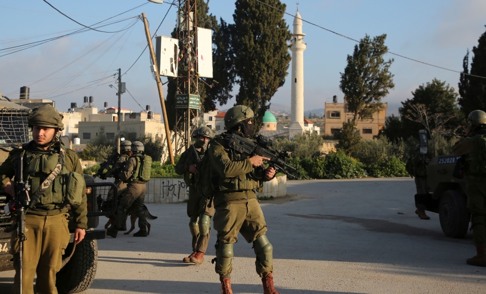 


Israeli security forces patrol a street in the northern West Bank village of Salem, east of Nablus, on Monday during a search operation for a Palestinian suspect. An Israeli soldier was killed and two other people were wounded Sunday when a Palestinian carried out a stabbing and shooting attack near a settlement in the occupied West Bank, the army said. — AFP