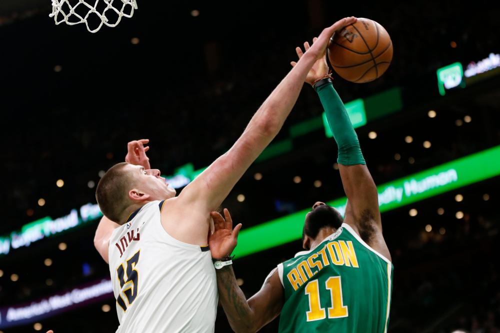 Denver Nuggets’ center Nikola Jokic blocks a shot by Boston Celtics’ guard Kyrie Irving during their NBA game at TD Garden in Boston Monday. — Reuters