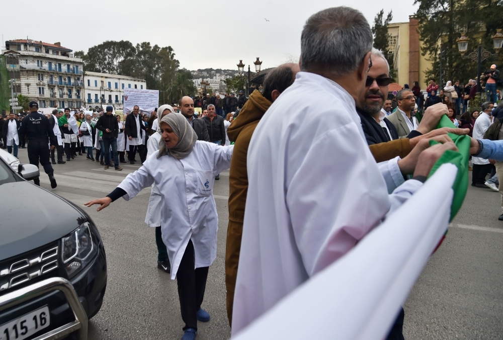 


Algerian health care professionals take part in a demonstration in the capital Algiers, Tuesday.  Algerian President Abdelaziz Bouteflika has said he will stay in power beyond his term expiring next month, despite tens of thousands of people demonstrating against his rule. — AFP
