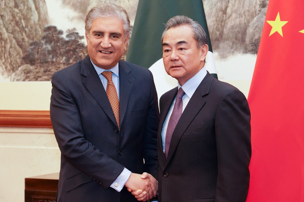 Chinese Foreign Minister Wang Yi shakes hands with Pakistani Foreign Minister Shah Mehmood Qureshi during a meeting at Diaoyutai State Guesthouse in Beijing, China, on Tuesday. — Reuters