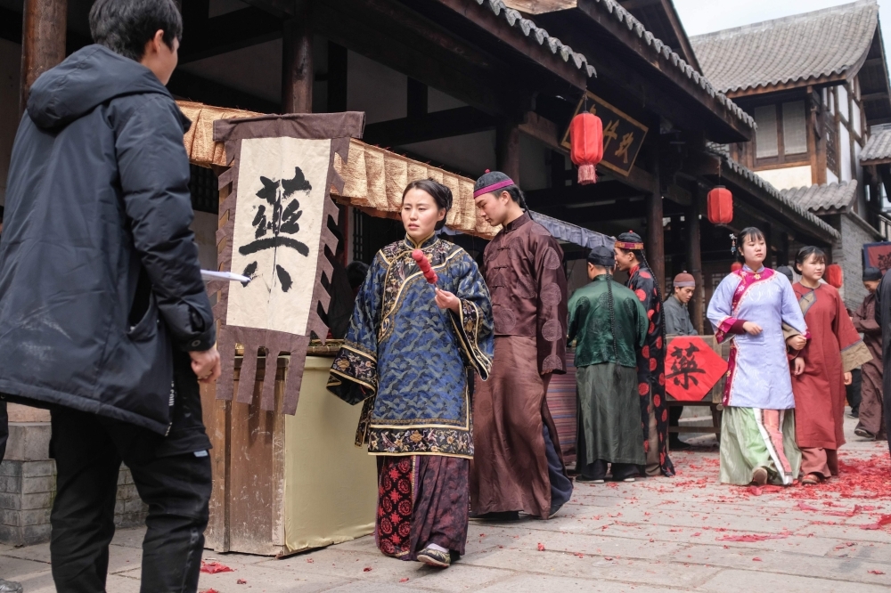 Extras dressed in period costume walking on set during filming for a Chinese TV drama at Hengdian World Studios in Dongyang in China's eastern Zhejiang province. — AFP