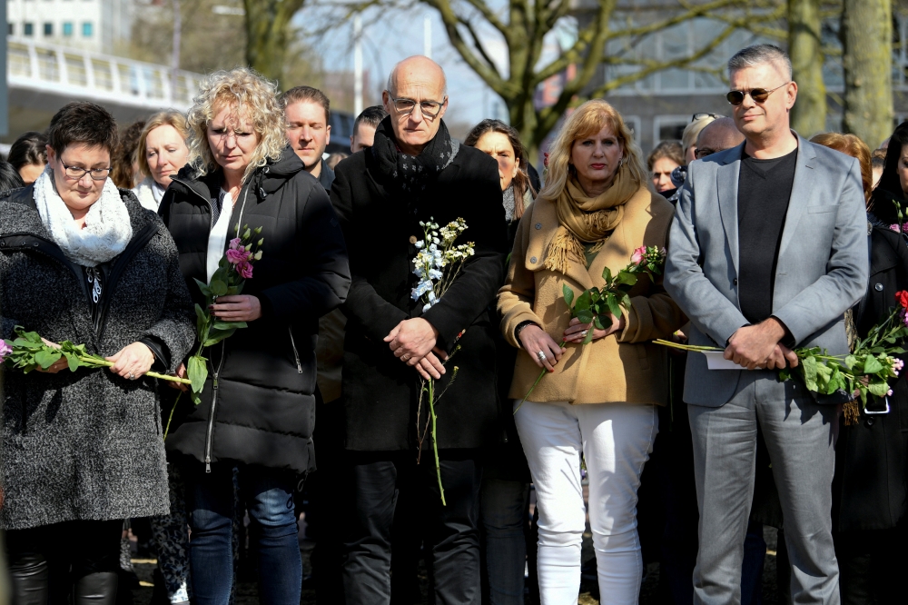 People hold flowers at a makeshift memorial at the site of a tram shooting in Utrecht, Netherlands, on Tuesday. — Reuters