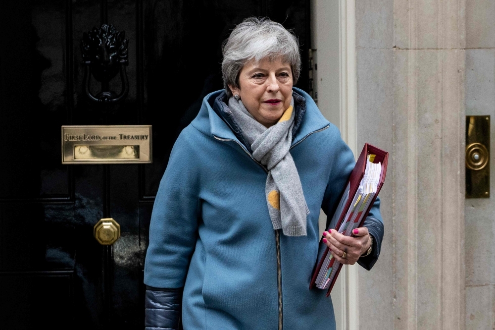 Britain’s Prime Minister Theresa May leaves 10 Downing Street in London on Wednesday ahead of the weekly Prime Minister’s Questions (PMQs) session in the House of Commons. — AFP