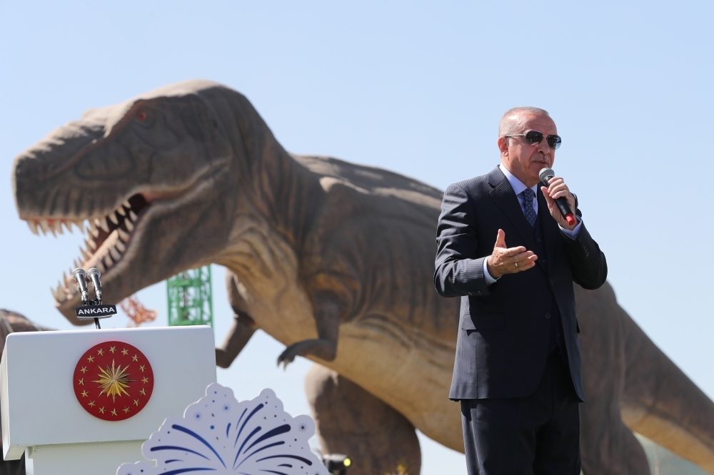 Turkish President Recep Tayyip Erdogan delivers a speech next to a model dinosaur during the opening ceremony of the Wonderland Eurasia theme park in Ankara. — AFP