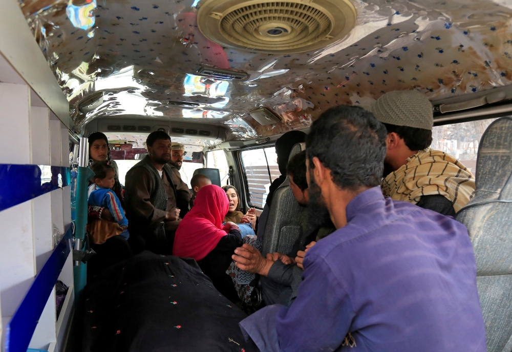 A family reacts inside an ambulance after they lost a family member after multiple explosions in Kabul, Afghanistan, on Thursday. — Reuters