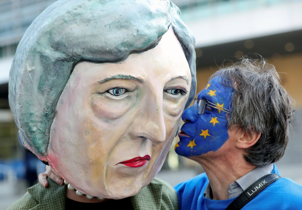 An anti-Brexit demonstrator kisses a protester dressed as Britain’s Prime Minister Theresa May ahead of a EU Summit in Brussels, Belgium, on Thursday. — Reuters