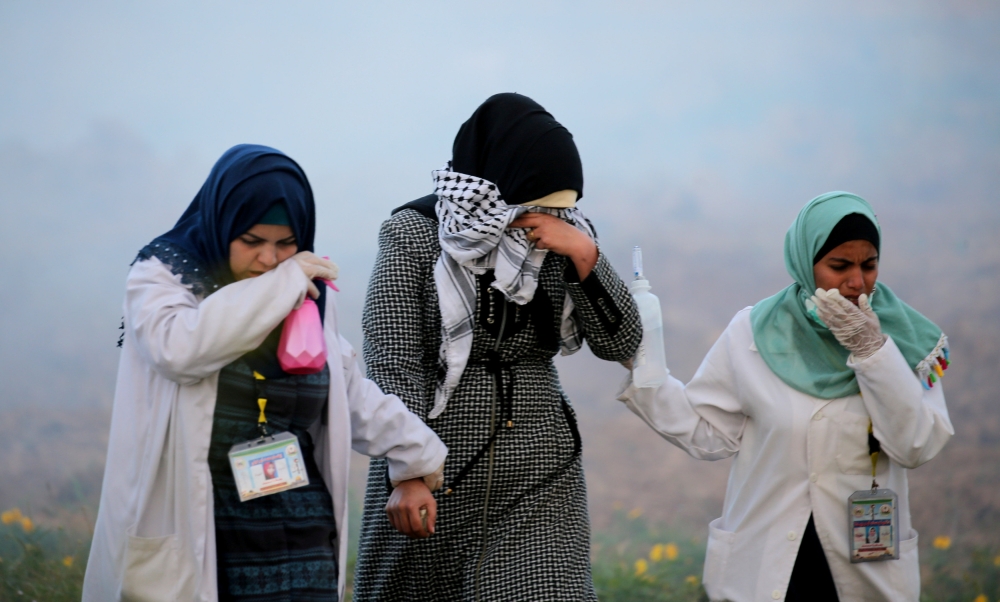 Palestinians react from tear gas fired by Israeli troops during a protest at the Israel-Gaza border fence, in the southern Gaza Strip in this Feb. 22, 2019 file photo. — Reuters