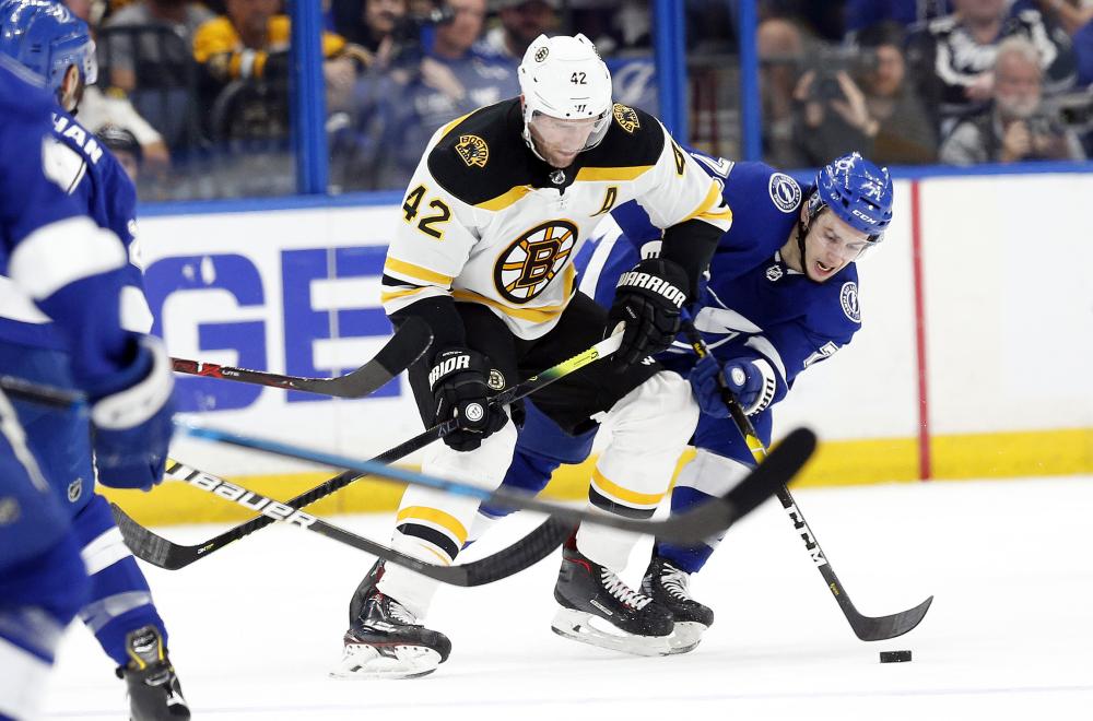Boston Bruins’ right wing David Backes (C) and Tampa Bay Lightning’s center Anthony Cirelli (R) battle for the puck during their NHL game at Amalie Arena in Tampa Monday. — Reuters