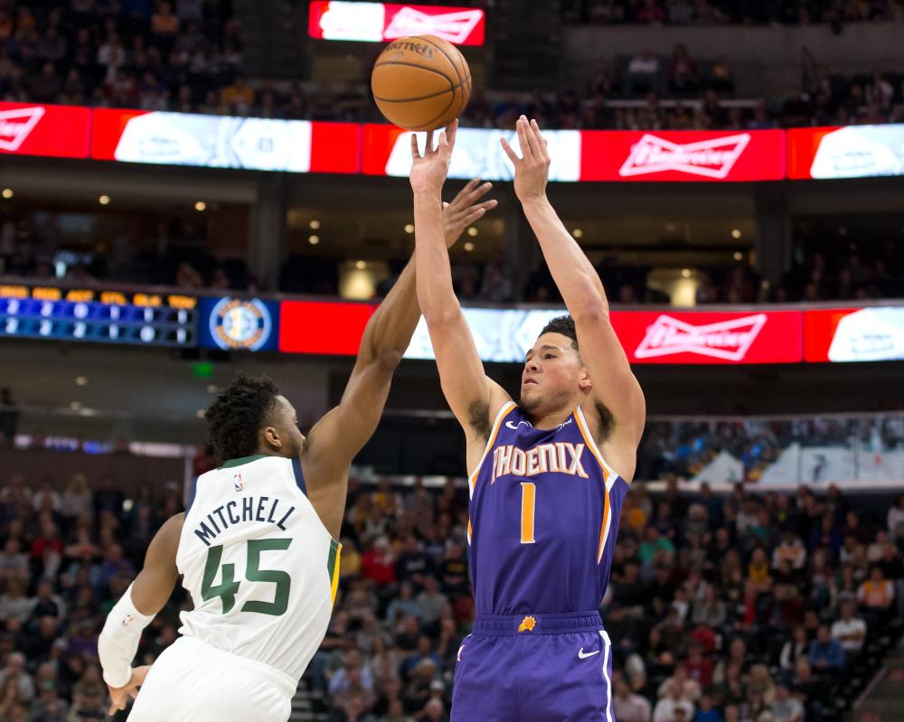 Phoenix Suns’ guard Devin Booker shoots the ball against Utah Jazz guard Donovan Mitchell during their NBA game at Vivint Smart Home Arena n Salt Lake City Monday. — Reuters