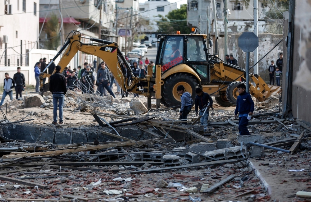 An excavator clears debris next to the destroyed office of Hamas leader in Gaza City, Ismail Haniya, that was targeted the night before by an Israeli air raid in this March 26, 2019 file photo. — AFP