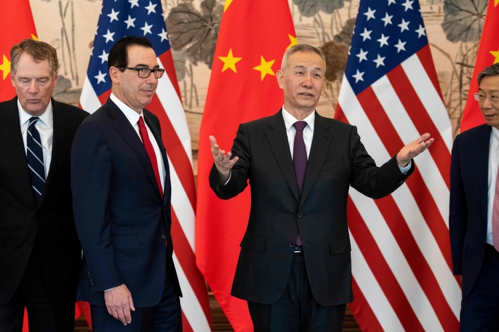 China's Vice Premier Liu He (2nd R) gestures next to US Treasury Secretary Steven Mnuchin (2nd L) and Yi Gang (R), governor of the People's Bank of China (PBC), as US Trade Representative Robert Lighthizer (L) looks on as they pose for a group photo at the Diaoyutai State Guesthouse in Beijing on Friday. Top negotiators from China and the United States resumed a fresh round of trade talks in Beijing aiming to settle the bruising spat that has threatened the global economy. — AFP