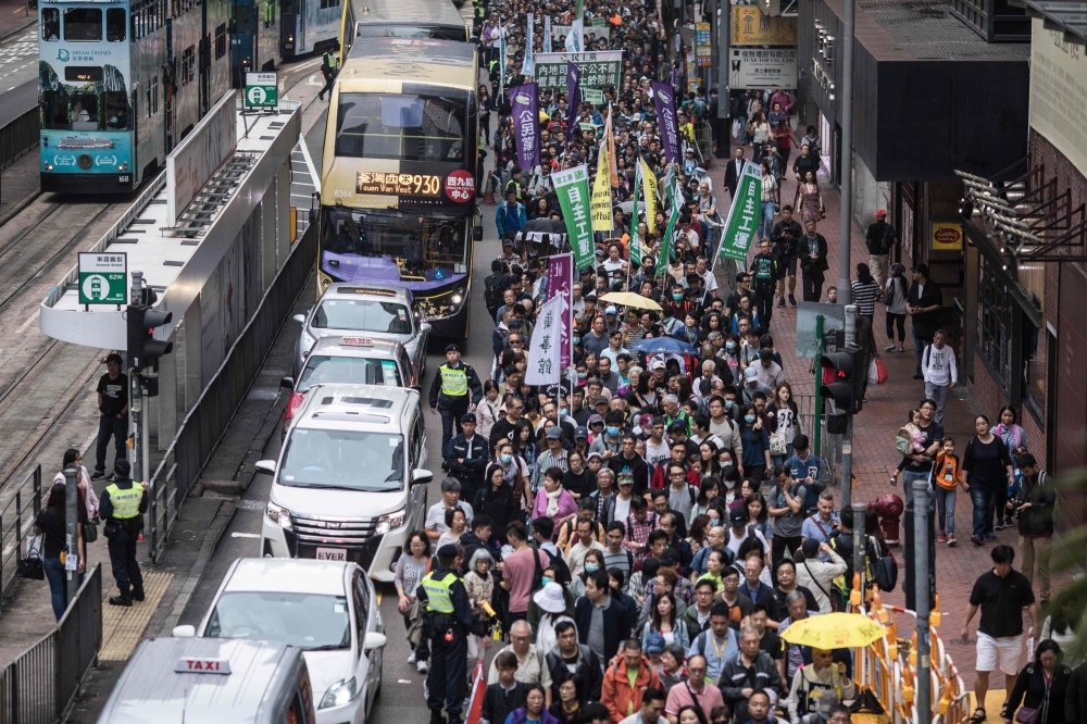 Protesters march along a street during a rally in Hong Kong on Sunday to protest against the government's plans to approve extraditions with mainland China, Taiwan and Macau. — AFP