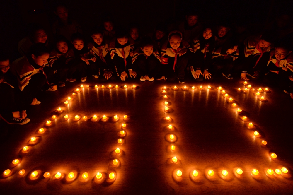 Students place candles during an event marking Earth Hour at a primary school in Handan, Hebei province, China. — Reuters