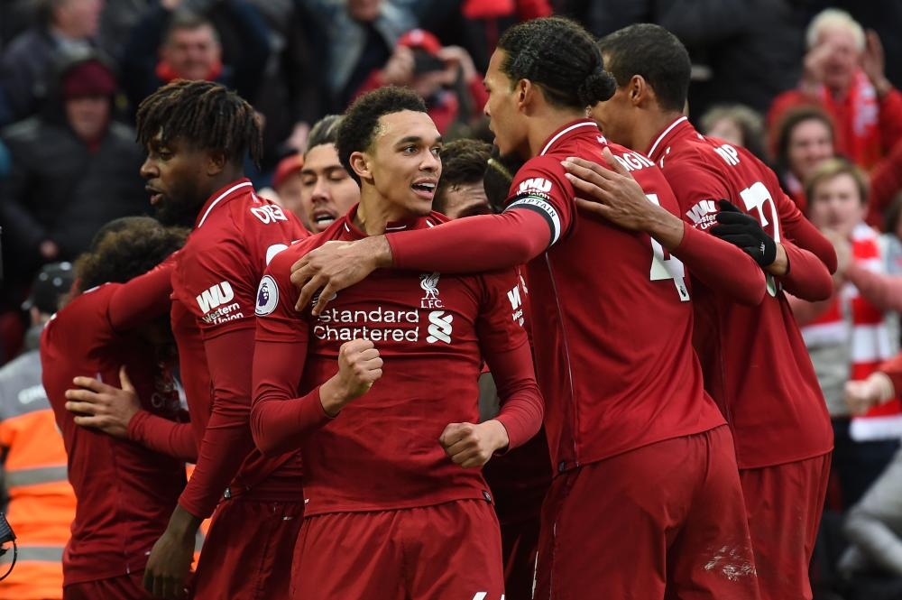 Liverpool's players celebrate after a late Tottenham Hotspur own goal during their English Premier League match at Anfield in Liverpool Sunday. — AFP