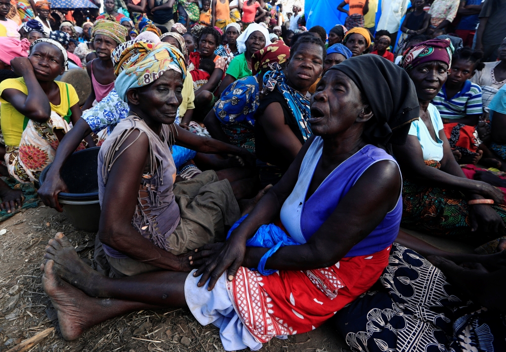 Women wait to receive aid at a camp for the people displaced in the aftermath of Cyclone Idai in John Segredo near Beira, Mozambique, on Sunday. — Reuters