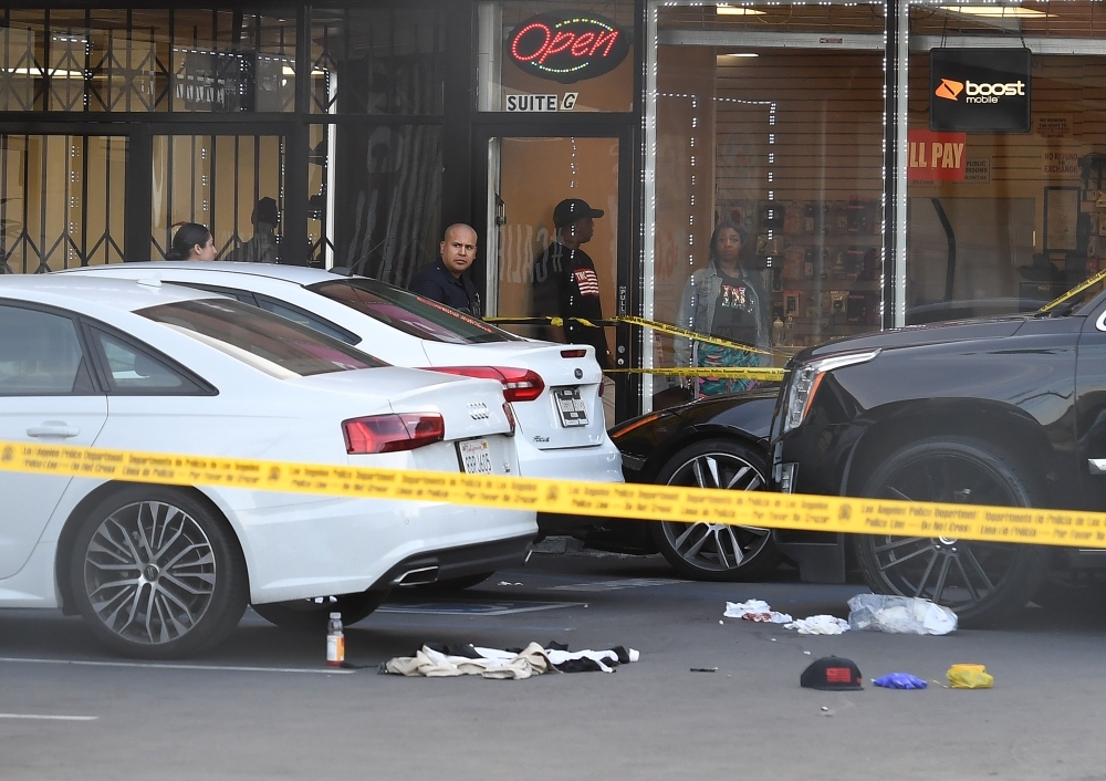 Blood stained bandages on the ground outside The Marathon clothing store owned by Grammy-nominated rapper Nipsey Hussle (INSET) where he was fatally shot along with 2 other wounded, in Los Angeles. — AFP