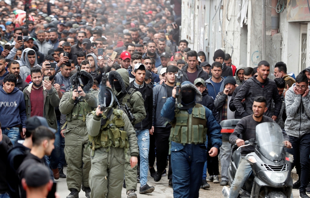 


Militants fire weapons in the air as mourners march during the funeral of Palestinian Mohammed Edwan, who was killed during clashes in an Israeli raid, near Ramallah, Tuesday. — Reuters