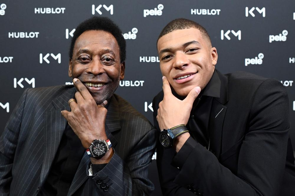 TOPSHOT - Paris Saint-Germain (PSG) and France national football team forward Kylian Mbappe (R) and Brazilian football legend Pele pose during their meeting at the Hotel Lutetia in Paris on April 2, 2019. / AFP / FRANCK FIFE
