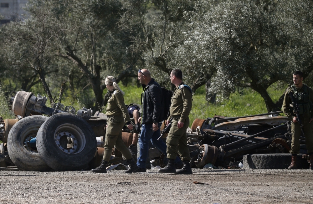Israeli soldiers inspect the site where a Palestinian man was killed after he reported tried to stab an Israeli driver at a junction south of Nablus in the occupied West Bank on Wednesday. — AFP
