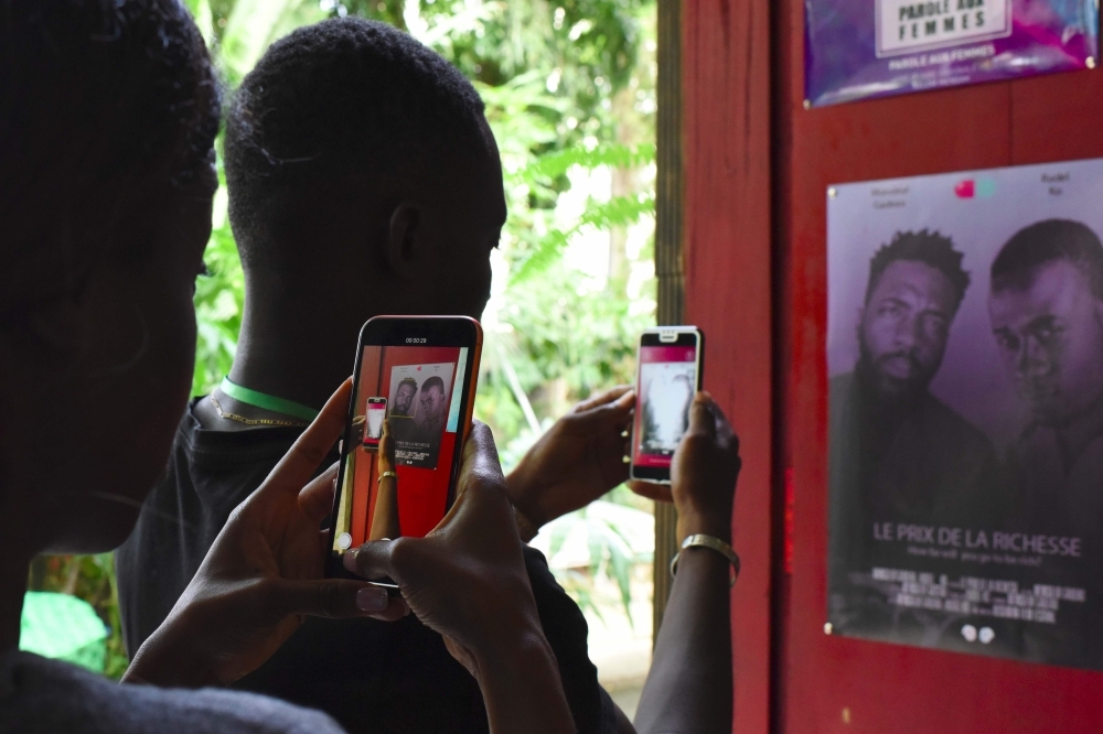 Two participants in a workshop film with their smartphones on March 30, 2019 during the 2nd edition of the Bushman Film Festival, the first Francophone film festival in West Africa focused of smartphone filming, in Abidjan. — AFP