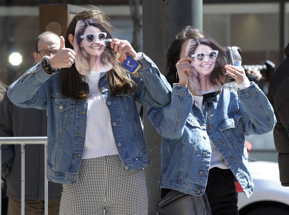 Two girls wear Lori Loughlin mask at the John Joseph Moakley United States Courthouse in Boston, Massachusetts, on Wednesday. — AFP