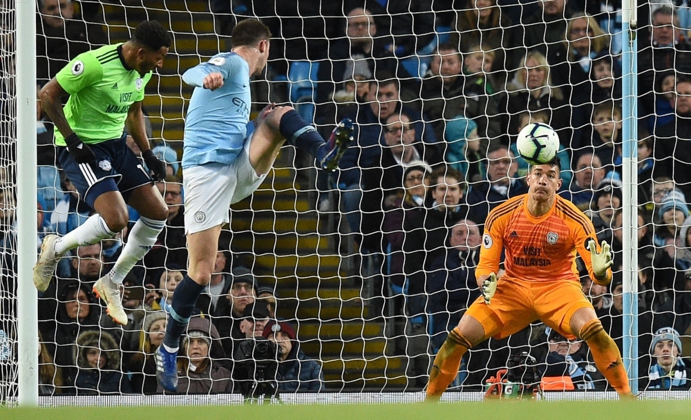 Manchester City's French defender Aymeric Laporte (2L) watches as Cardiff City's English-born Filipino goalkeeper Neil Etheridge (R) saves his shot during the English Premier League football match at the Etihad Stadium in Manchester, north west England, Wednesday. — AFP