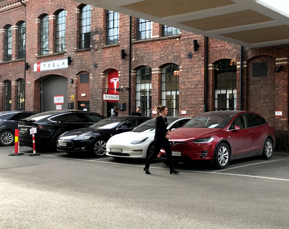 A woman walks past parked Tesla electric vehicles at the delivery site of Tesla in Lillestrom, Norway. — Reuters