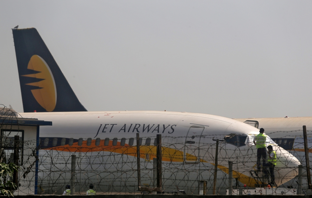 Workers cover the cockpit window of a Jet Airways aircraft parked at the Chhatrapati Shivaji Maharaj International Airport in Mumbai, India, in this recent photo. — Reuters