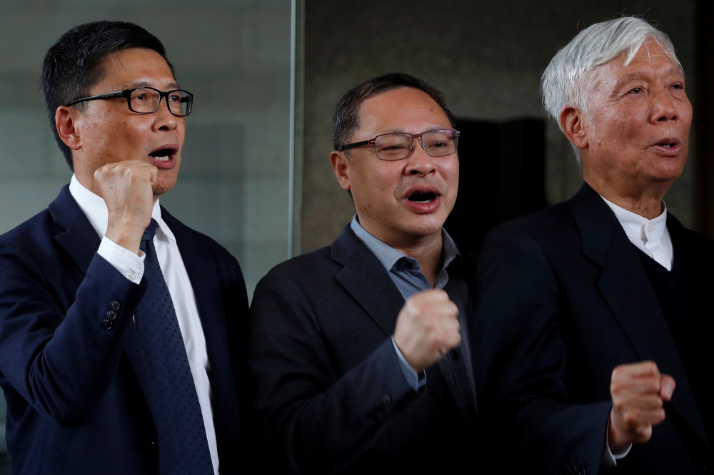 Occupy Central pro-democracy movement founders Chan Kin-man, left, Benny Tai, center, and Chu Yiu-ming, right, chant slogans after found guilty over the Occupy Central, also known as “Umbrella Movement”, in Hong Kong, China, on Tuesday. — Reuters
