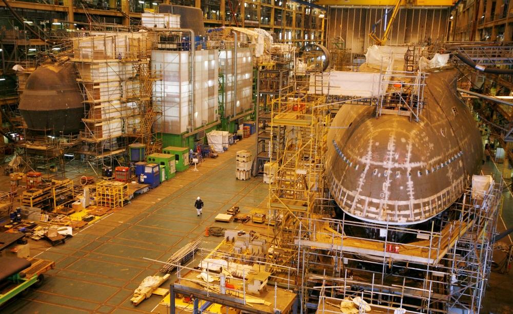 A worker walks between the first two Astute class nuclear submarines as they are built in the Devonshire Dock hall at the BAE systems facility in Barrow-in-Furness, northern England, in this May 8, 2007 file photo. — Reuters