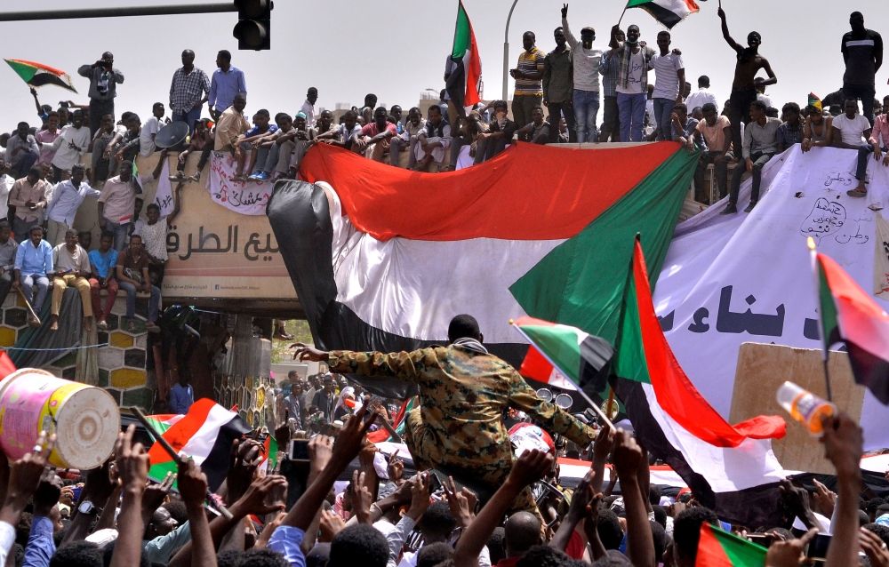 Sudanese demonstrators chant slogans along the streets after Sudan’s Defense Minister Awad Mohamed Ahmed Ibn Auf said that President Omar Bashir had been detained “in a safe place” and that a military council would run the country for a two-year transitional period in Khartoum, Sudan, on Thursday. — Reuters