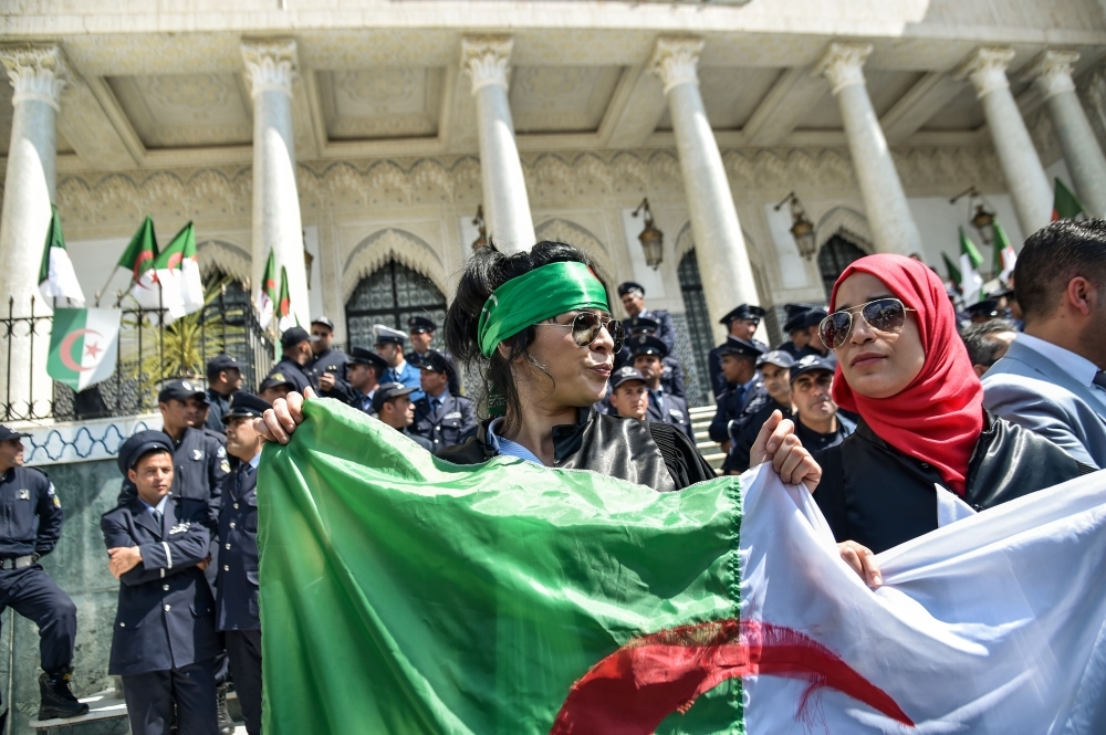 Algerian women wave a national flag during a demonstration for the independence of the judiciary outside the Justice Ministry headquarters in the capital Algiers, Saturday. — AFP. 