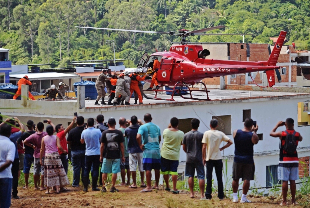 People watch as an injured person is carried onto a rescue helicopter after two buildings collapsed in Muzema, Rio de Janeiro, Brazil, in this April 12, 2019 file photo. — AFP