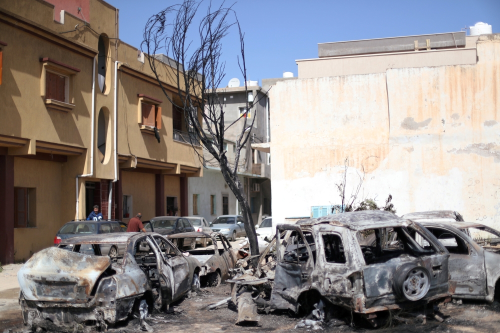 Vehicles damaged by an overnight shelling are seen in Abu Salim District in Tripoli, on Tuesday. — Reuters