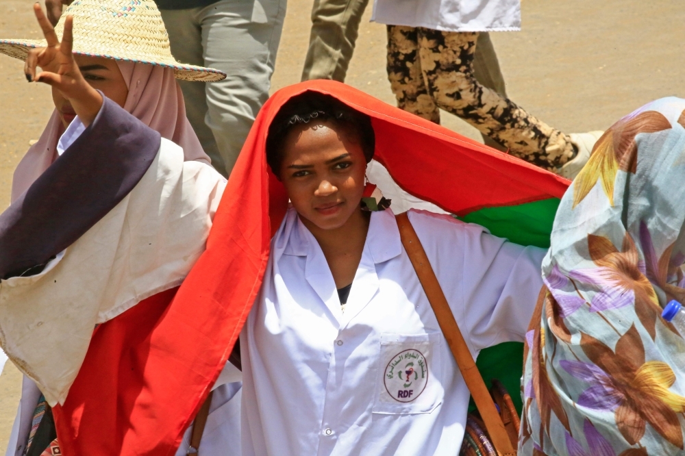 Sudanese protesters wave signs as they continue to protest outside the army complex in the capital Khartoum on Wednesday. — AFP