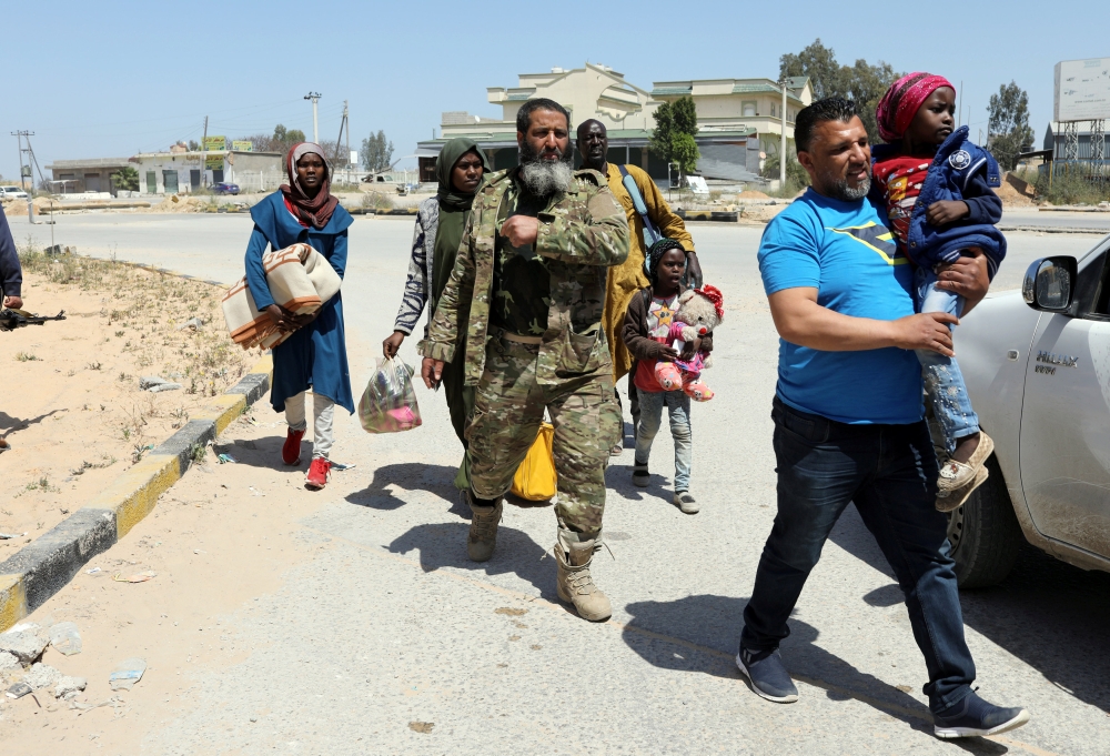 Members of Libyan internationally-recognized government forces evacuate an African family during fighting with Eastern forces, at Al-Swani area in Tripoli, Libya on Thursday. — Reuters