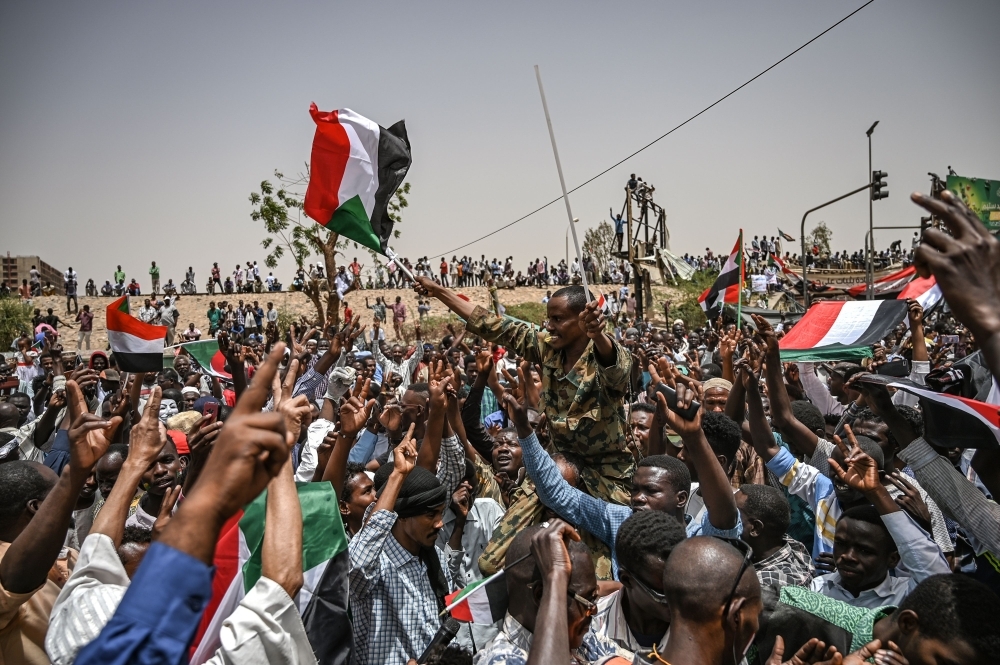 Protestors shout slogans outside the army complex in the capital Khartoum, Thursday. — AFP