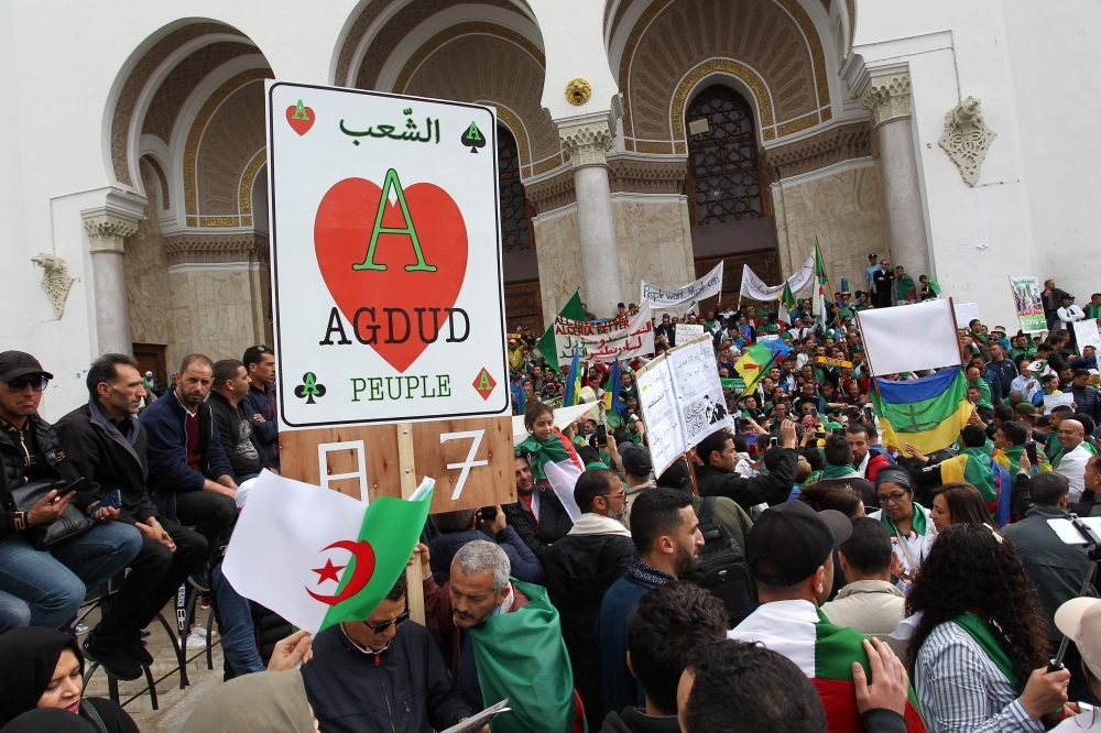 Algerian protesters wave national flags and banners as they take part in an anti-government demonstration in front of La Grande Poste (main post office) in the center of the capital Algiers on Friday. — AFP