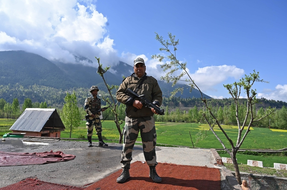 Indian Border Security Force (BSF) soldiers stand guard on the top of a polling station during a second phase of elections at Kangan, some 35 km from Srinagar on Thursday. — AFP