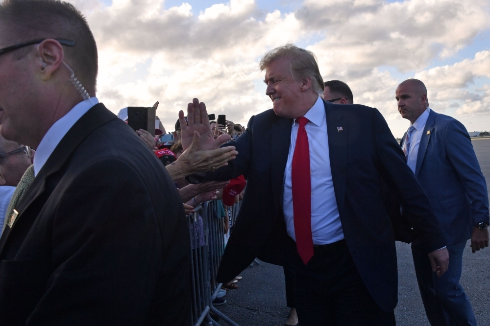 US President Donald Trump greets supporters upon arrival at Palm Beach International airport, Florida, on Thursday. — AFP